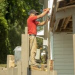 decking contractor showing how to build a deck. hammer in hand.