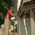 Construction working using a powertool on a deck.