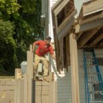 Construction working using a powertool on a deck.