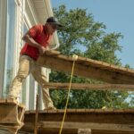 Construction worker lifting up deck boards