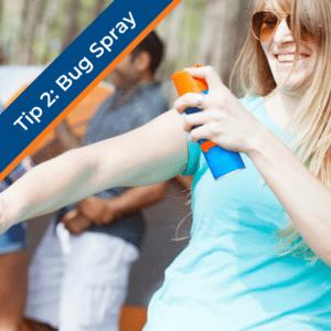 young woman spraying herself with bug spray