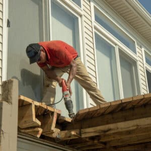 contractor cutting away old deck with a reciprocating saw