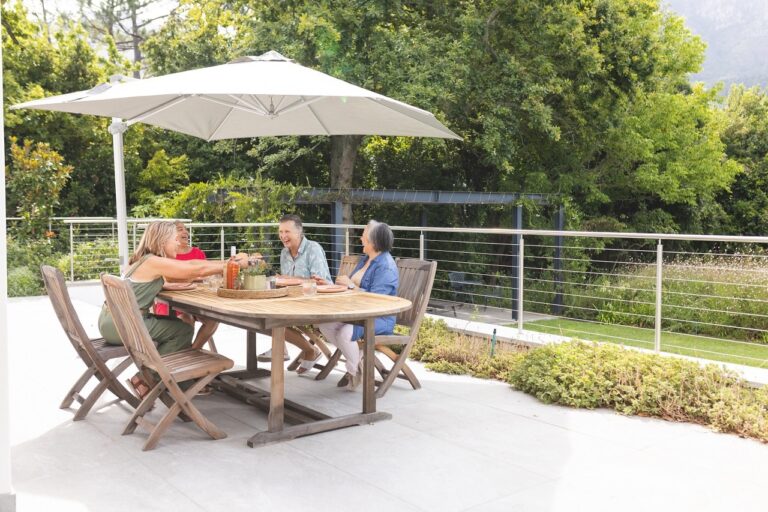 a family sitting at a patio table on a concrete deck. 