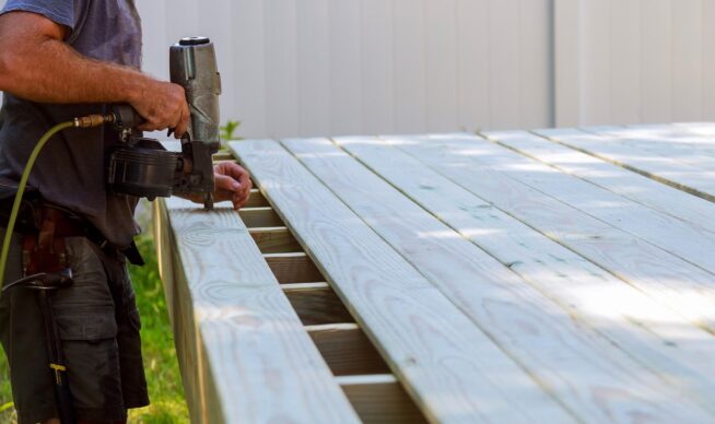 contractor bolting down deck boards.