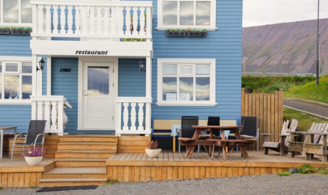 view of a multi-tier deck connected to a bright blue house.