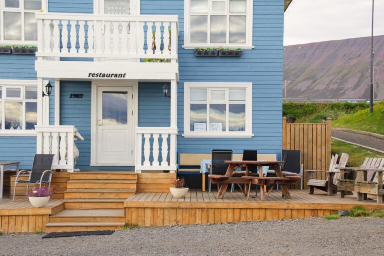 view of a multi-tier deck connected to a bright blue house.