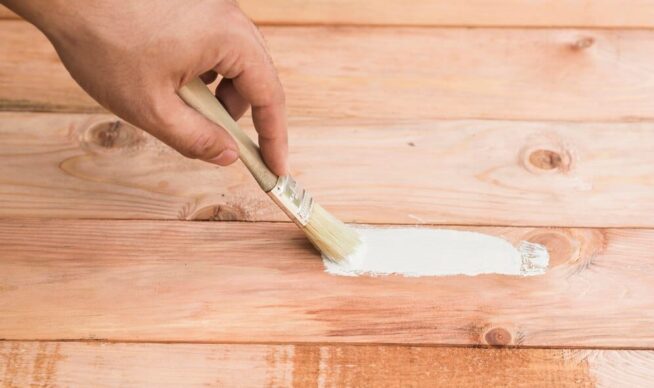 Stock image of a hand painting a wood deck.