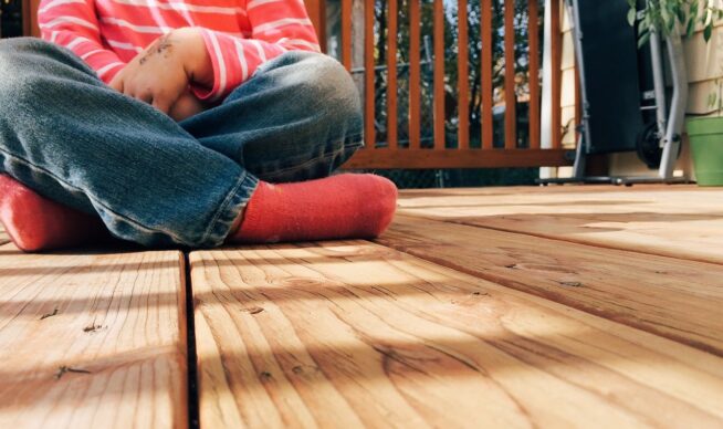 Child sitting on an outdoor deck