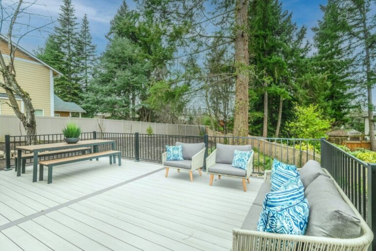Beautiful outdoor deck with chairs, sofa, and table