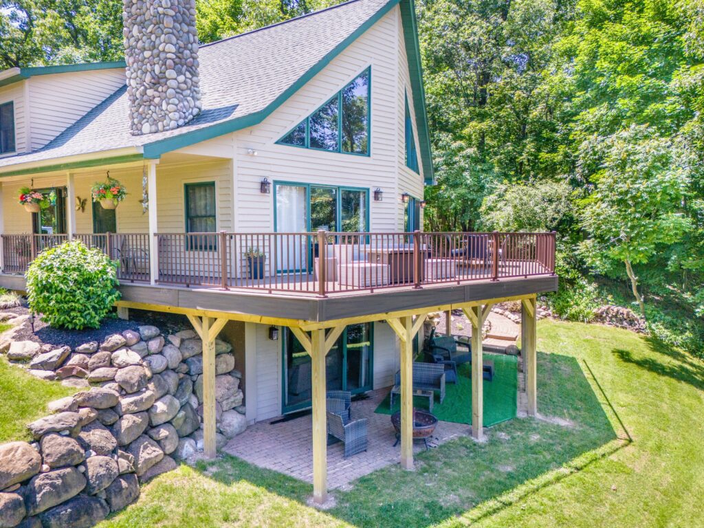 Completed custom wrap around composite deck with metal railing and dry space underneath