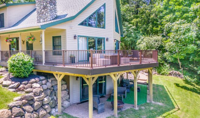 Completed custom wrap around composite deck with metal railing and dry space underneath